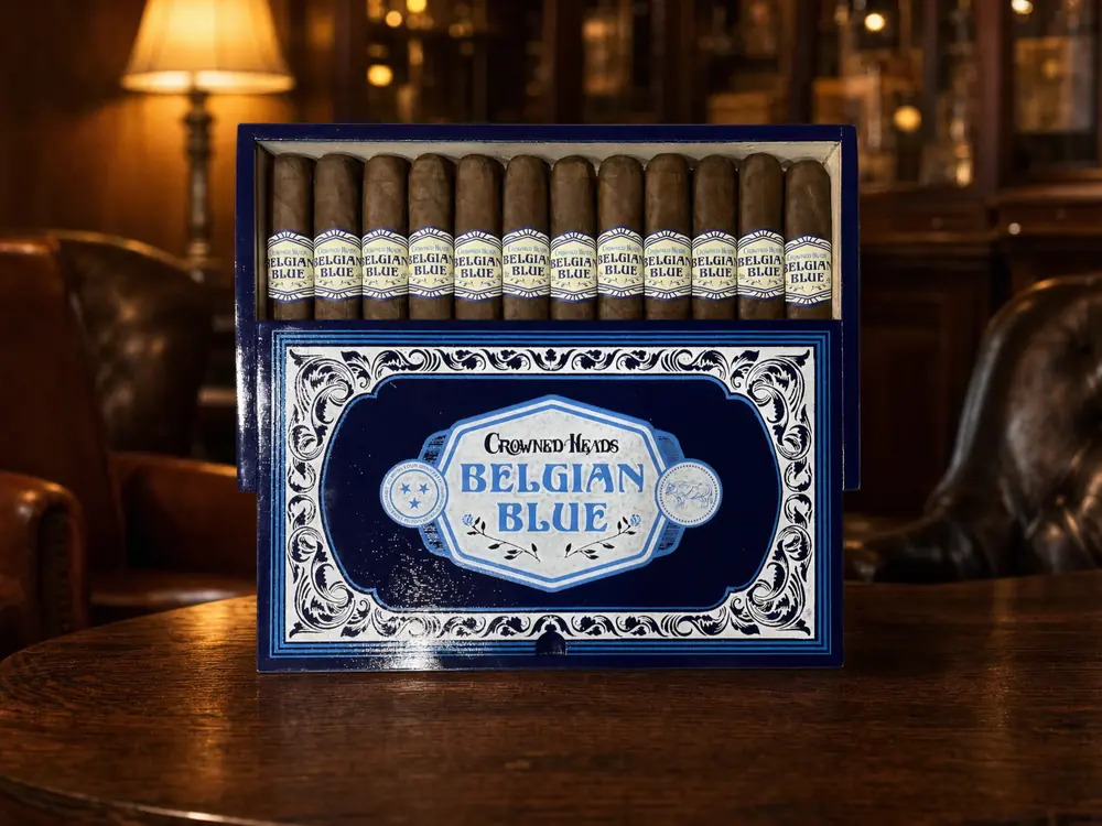 Navy Crowned Heads Belgian Blue 2026 box with twelve box-pressed robustos on a walnut table
